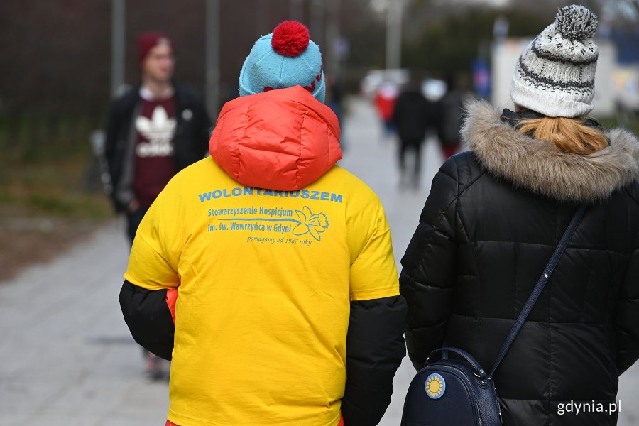 Jeden z wolontariuszy biorących udział w akcji „Pola Nadziei na Pomorzu”. Jest ubrany w żółtą koszulkę. Na głowie ma niebieską czapkę z czerwonym pomponem // fot. Michał Puszczewicz