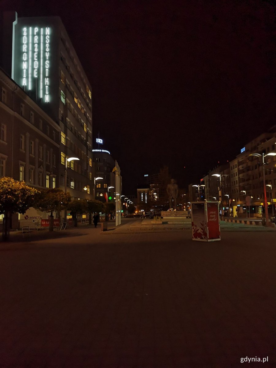 U góry po lewej: neon "Zdrowia przede wszystkim" na budynku szpitala im. św. Wincentego a Paulo w Gdyni. W centralnej części zdjęcia plac Kaszubski wieczorem 11 listopada // fot. Karolina Szypelt