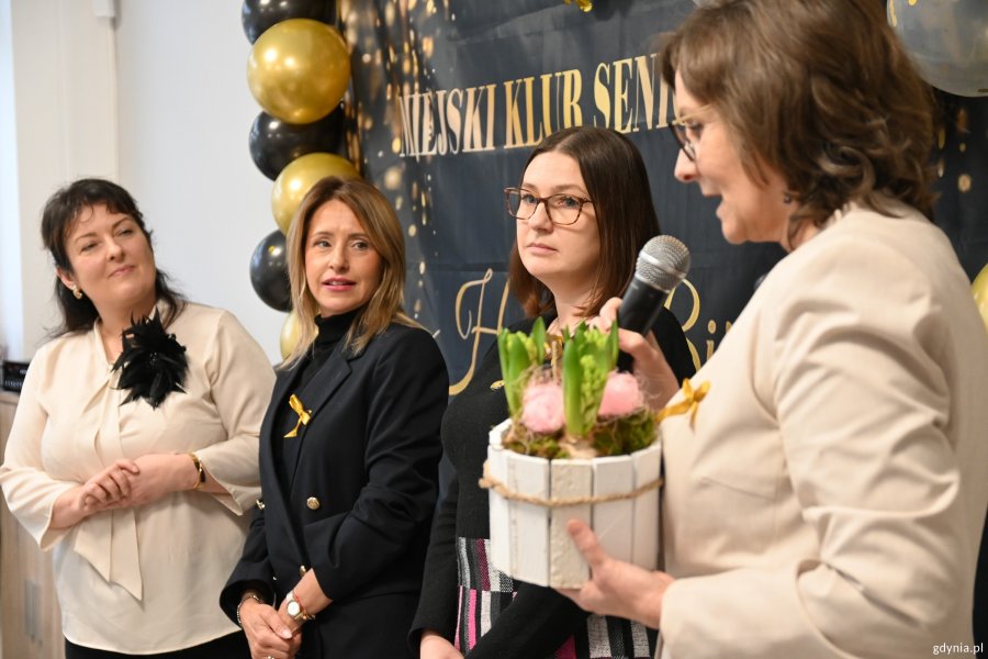 Trzy panie składają seniorom życzenia od zaprzyjaźnionego przedszkola