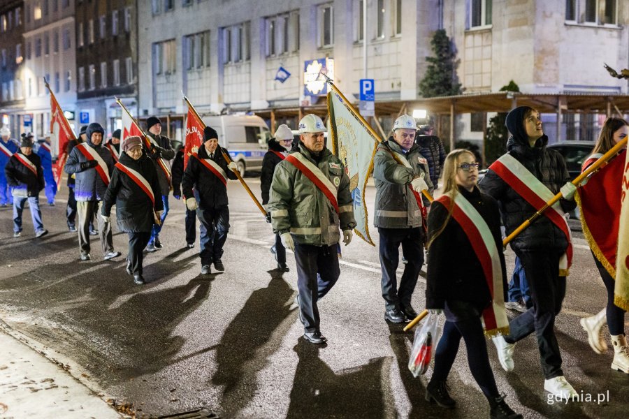 Ludzie w odświętnych strojach idący ulicą