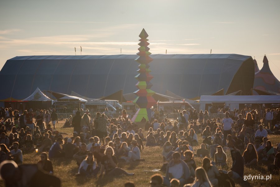 Uczestnicy Open'era zgromadzeni na terenie festiwalu w promieniach zachodzącego słońca // fot. Karol Stańczak