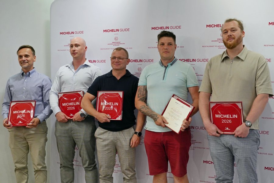 Restauratorzy, kt&oacute;rzy zdobyli rekomendacje przewodnika Michelin 2026 z plakietami. Wśr&oacute;d nich (w środku) Piotr Lemański z Butchery & Wine