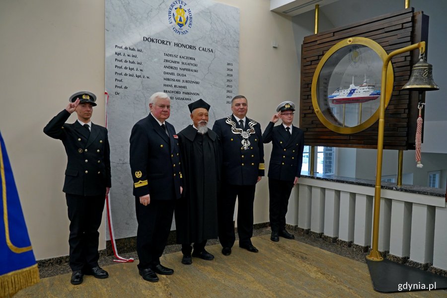Od prawej: prof. dr hab. inż. kpt. ż. w. Adam Weintrit &ndash; rektor Uniwersytetu Morskiego w Gdyni, dr Yohei Sasakawa i laudator oraz promotor doktoratu prof. dr hab. inż. Janusz Mindykowski przy tablicy pamiątkowej