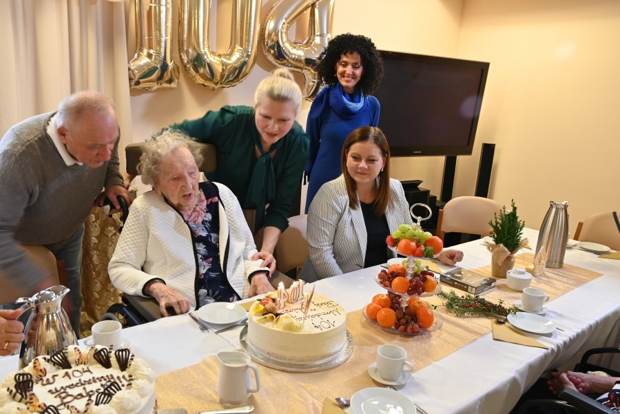 Prezydent Gdyni, Aleksandra Kosiorek pomaga zdmuchnąć świeczki na torcie pani Janiny