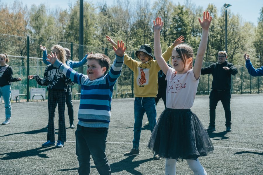 Zumba na boisku szkolnym, na pierwszym planie dwoje dzieci