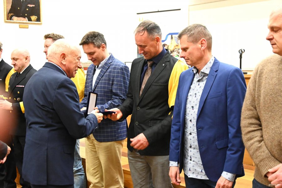 Grupa mężczyn z ż&oacute;łtymi chustami na scenie