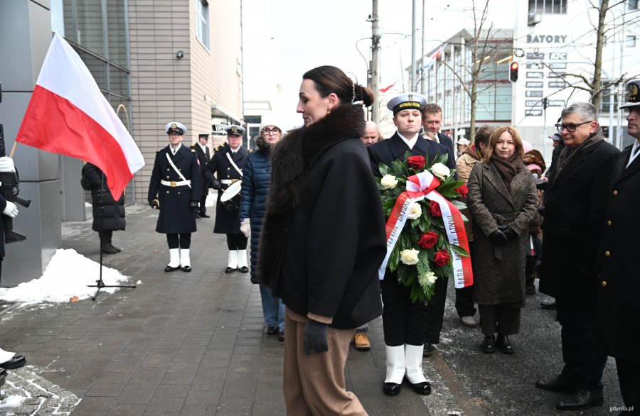 Kobieta w eleganckim stroju i marynarz z kwiatami