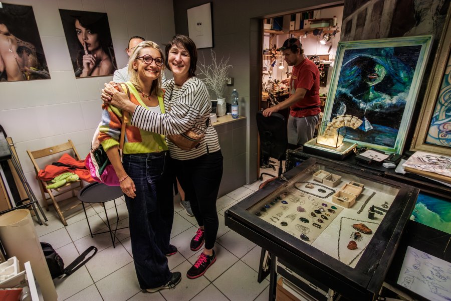 Dwie uśmiechnięte kobiety i fotografie w tle