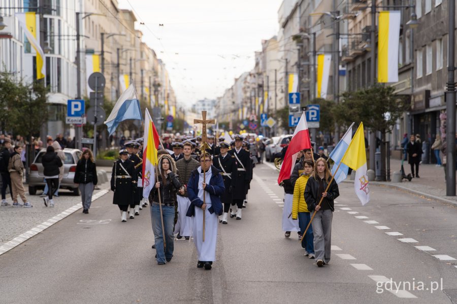 Ludzie idący w procesji ul. Świętojańską