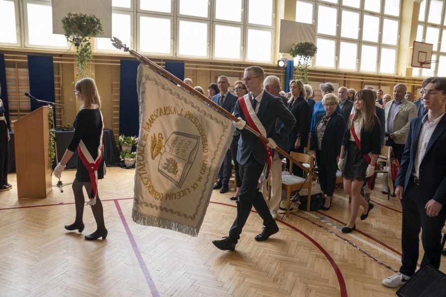 Poczet sztandarowy, w tle stojąca publiczność uroczystości