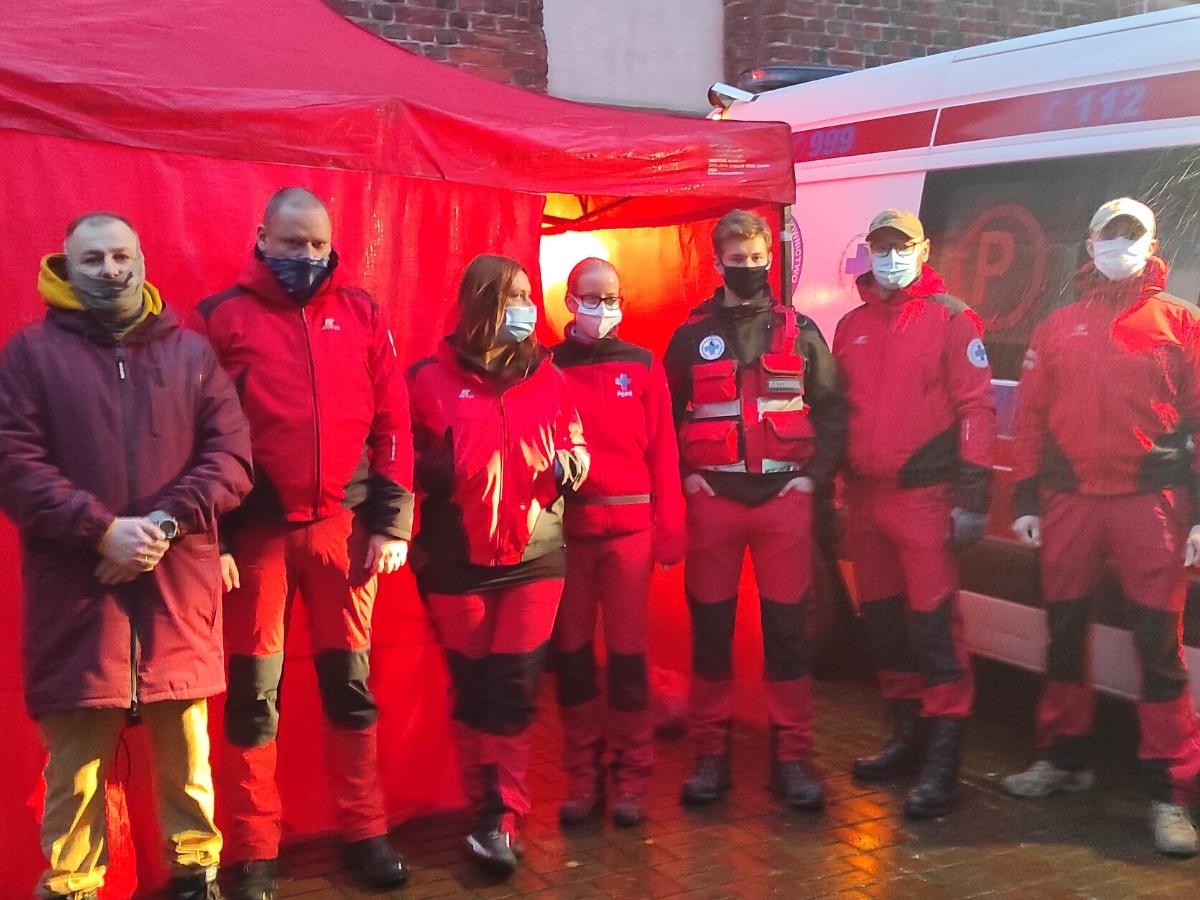 Grupa ratownik&oacute;w medyczny stoi przed dużym namiotem