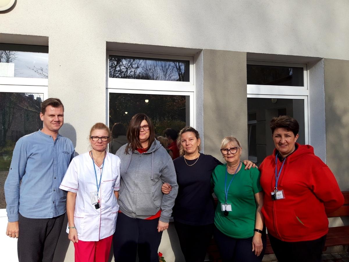 uśmiechnięte młode osoby na tle dużego budynku