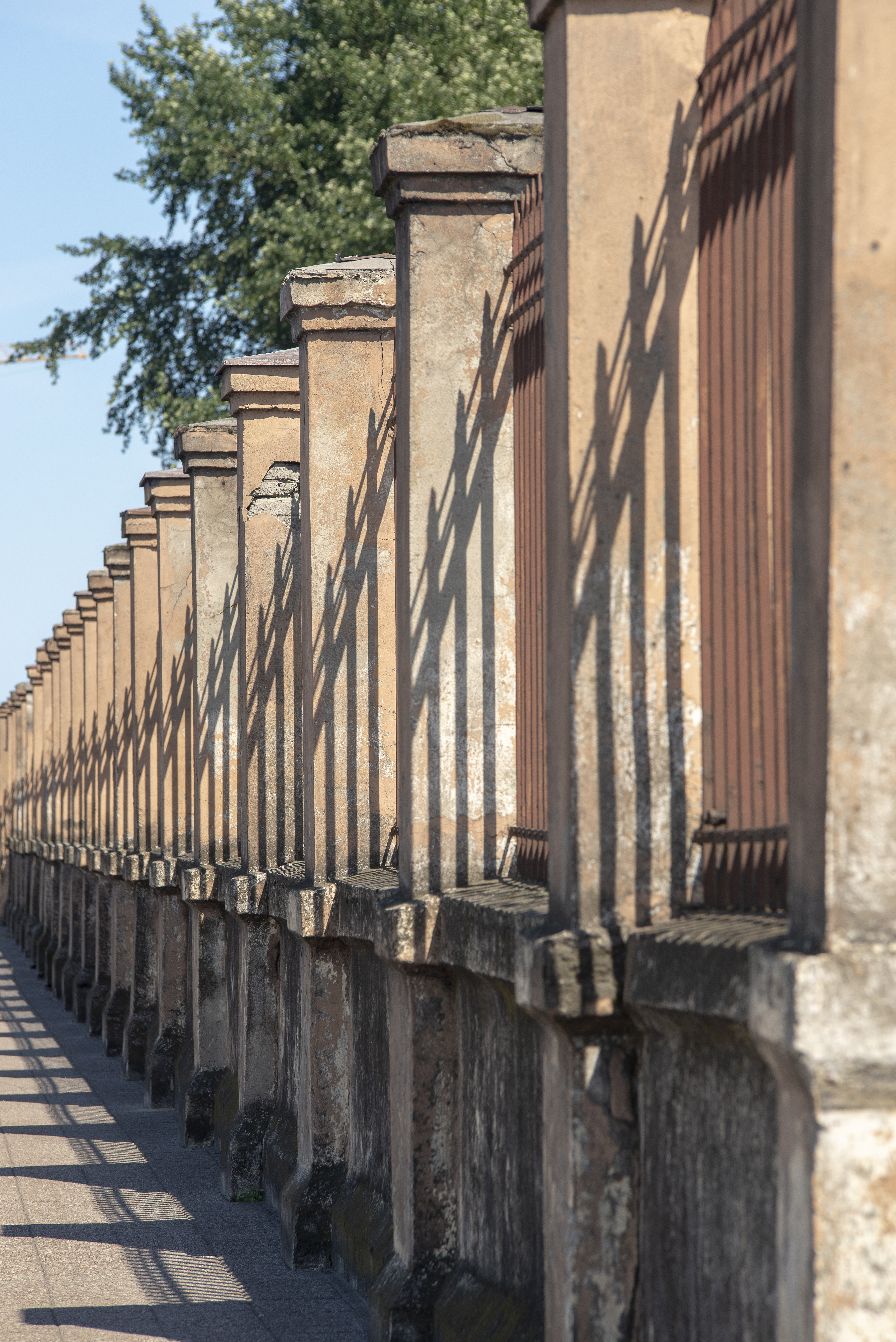 Rytm słup&oacute;w wspierających metalowe kraty ogrodzenia terenu Monopolu Tytoniowego przy ul. Polskiej