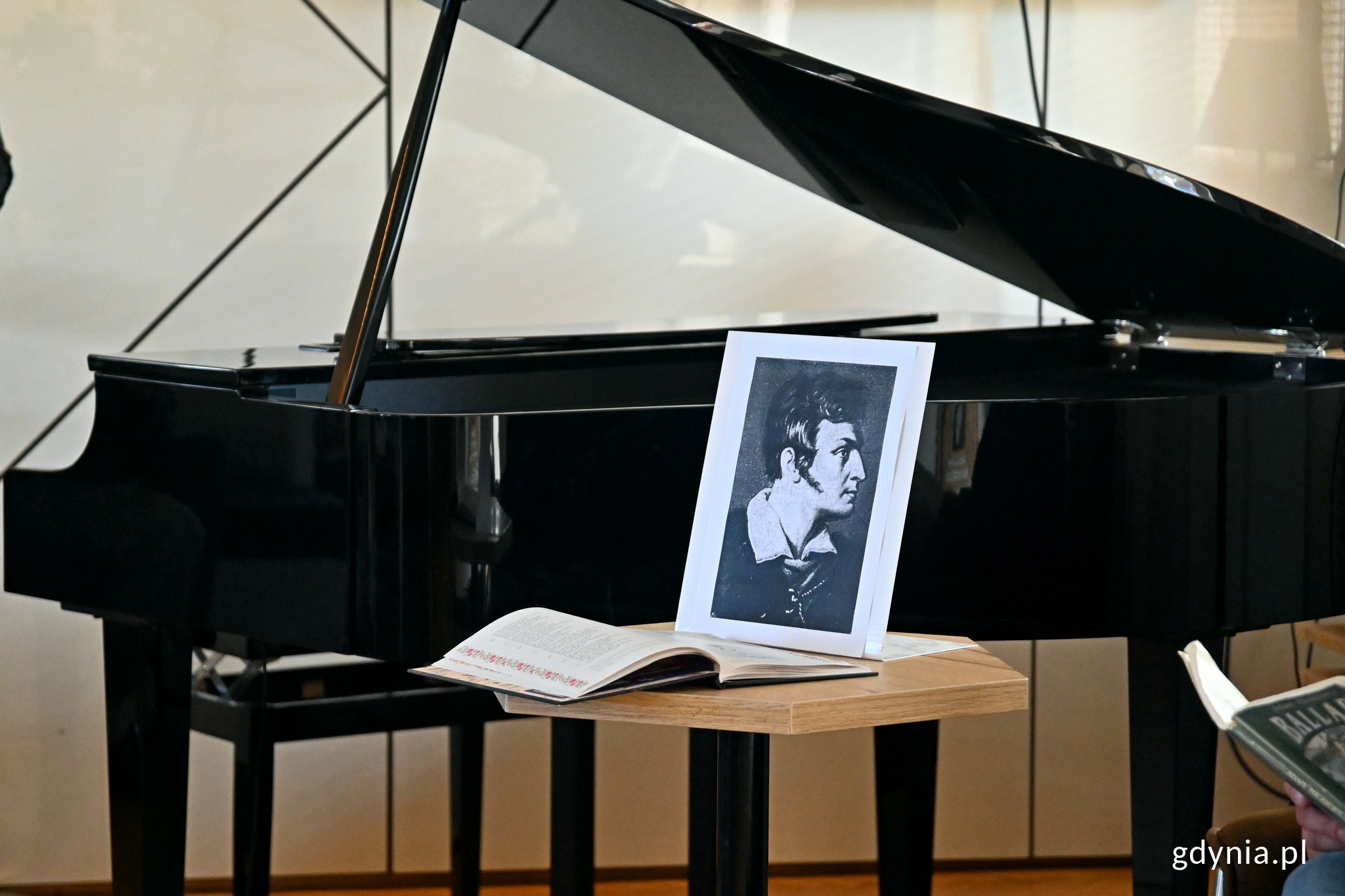 Czarno-biały portret Adama Mickiewicza ustawiony na stole na tle fortepianu w Konsulacie Kultury // fot. Magdalena Czernek