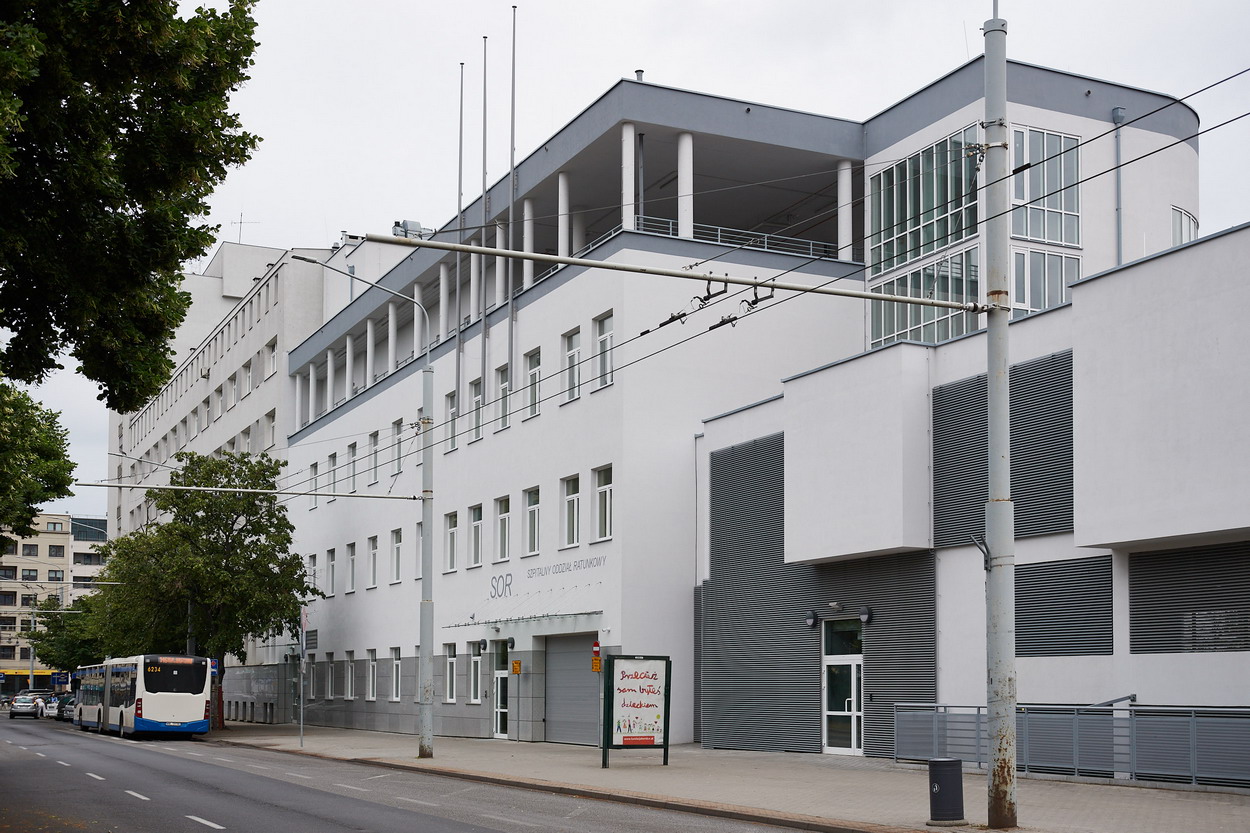 Budynek szpitala w Gdyni, widoczny SOR, biała elewacja, fragment ulicy