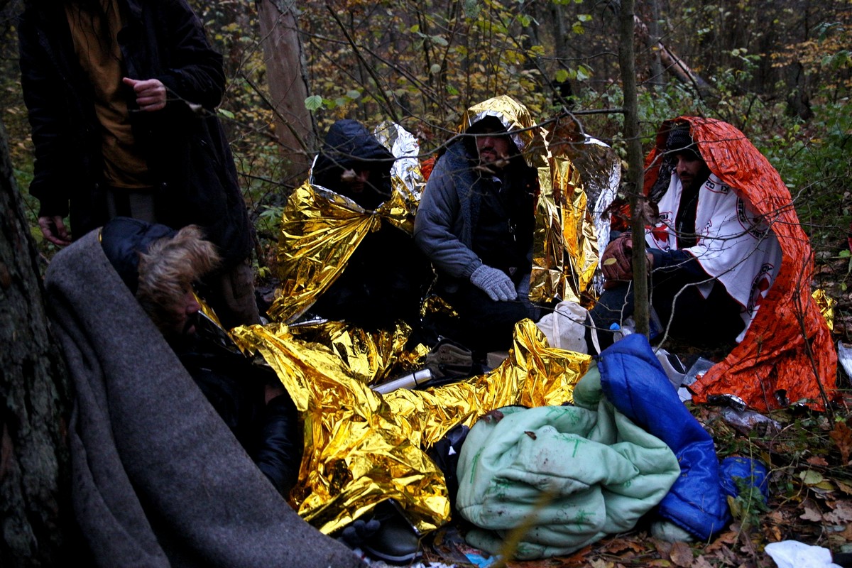 Wycieńczoni i wychłodzoni uchodźcy z Syrii, kt&oacute;rzy spędzili w lesie 10 dni, pr&oacute;bując wydostać się z potrzasku. Mężczyźni trzykrotnie byli już wypychani przez Straż Graniczną na stronę białoruską. Po udzieleniu im pomocy przez wolontariuszy z Grupy Granica, Medyk&oacute;w na granicy i fundację Ocalenie zostali ponownie odwiezieni za granicę. Lipiny, Podlasie, 23 października 2021. Fot. Przemysław Kozłowski / Testigo Documentary