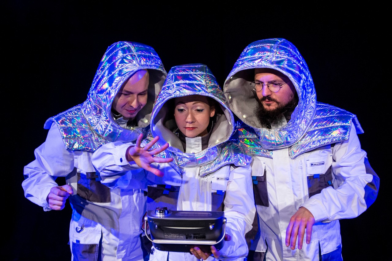 Przedstawienie „Dlaczego nie lecimy do gwiazd?” . Na zdj. troje aktorów w kombinezonach astronautów. Fot. Marzena Chojnowska