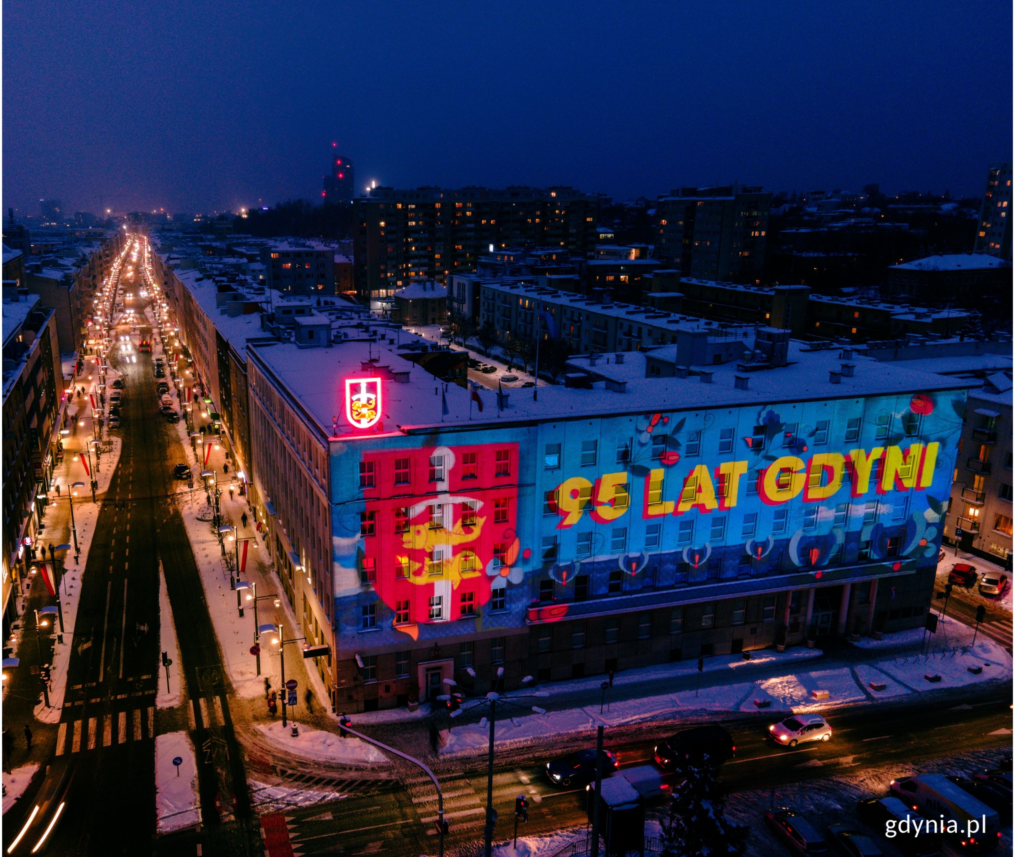 Widok z g&oacute;ry na budynek Urzędu Miasta Gdyni (ul. Marsz. Piłsudskiego 52/54), na kt&oacute;rego elewacji wyświetlany jest pokaz audiowizualny. Po lewej stronie widać oświetloną ulicę Świętojańską. // fot. Marcin Mielewski