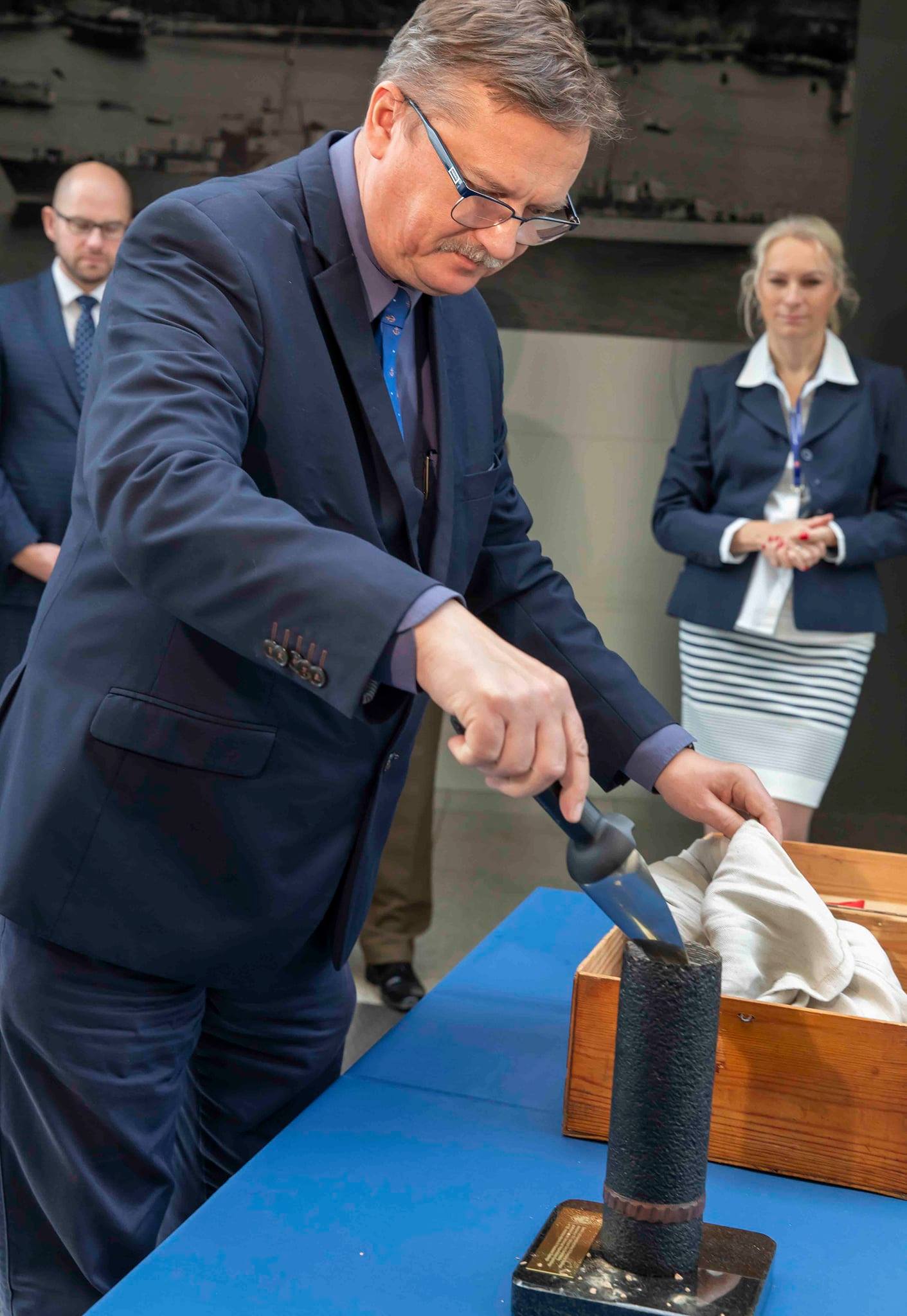 Tomasz Miegoń, dyrektor Muzeum Marynarki Wojennej, przesypuje ziemię do szklanki od szrapnela, czyli pocisku artyleryjskiego // fot. H. Nagrodzki / MMW