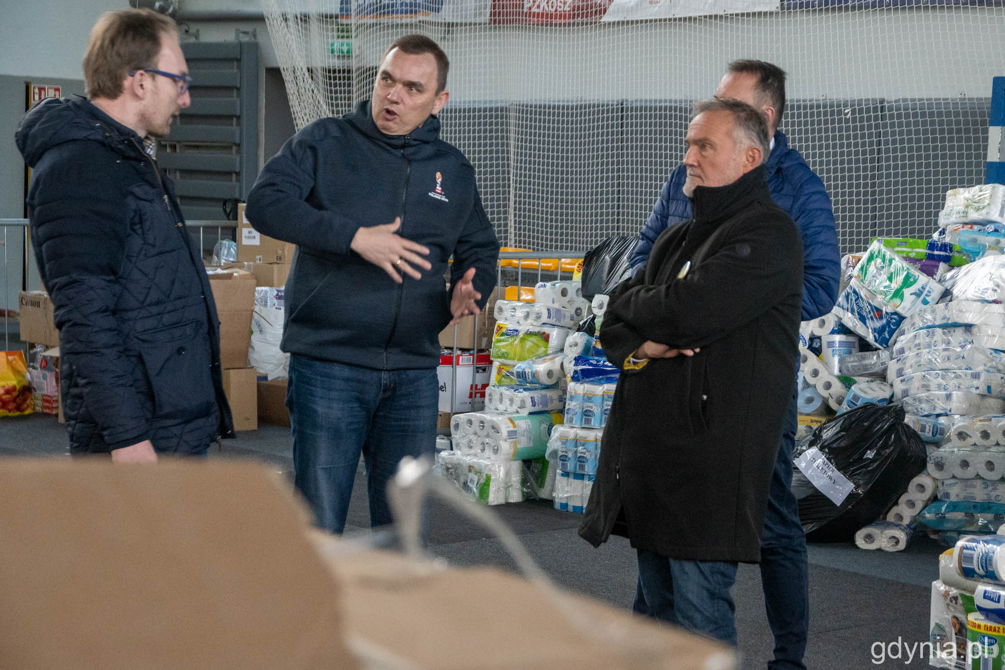 Hala Gier GCS stała się wielkim magazynem dar&oacute;w. Na zdjęciu od lewej: Jakub Ubych (wiceprzewodniczący Rady Miasta Gdyni), Przemysław Dalecki (dyrektor GCS), Wojciech Szczurek (prezydent Gdyni), fot. Paweł Kukla