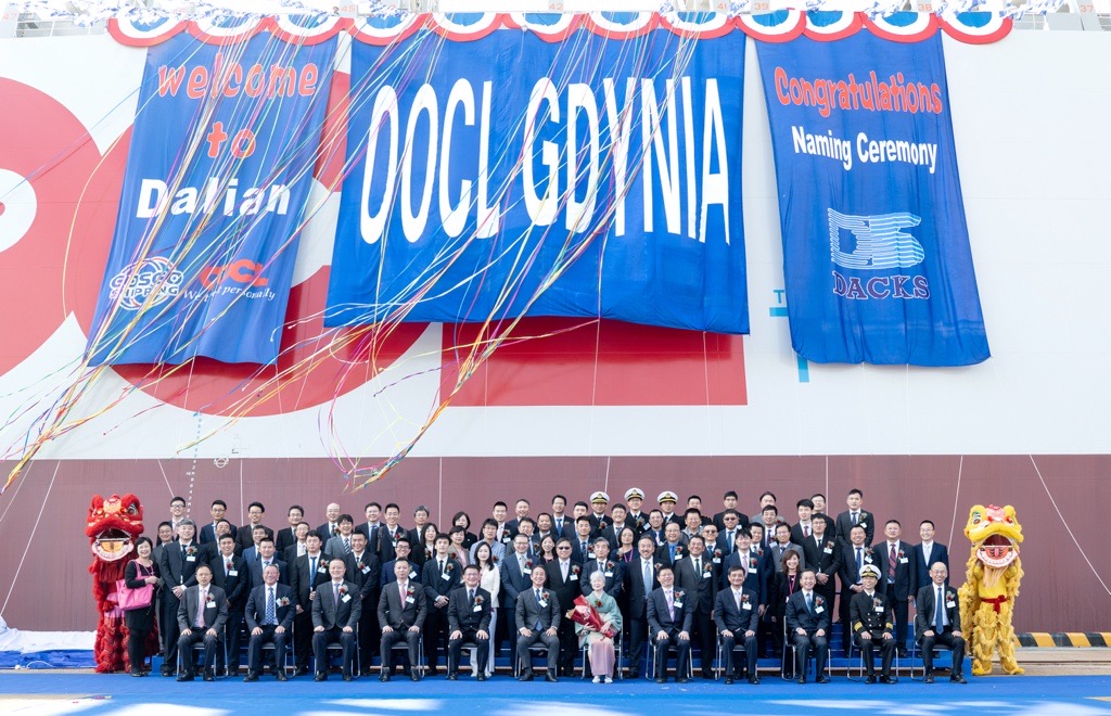 Tłum ludzi siedzi pod statkiem podczas ceremonii nadania nazwy.