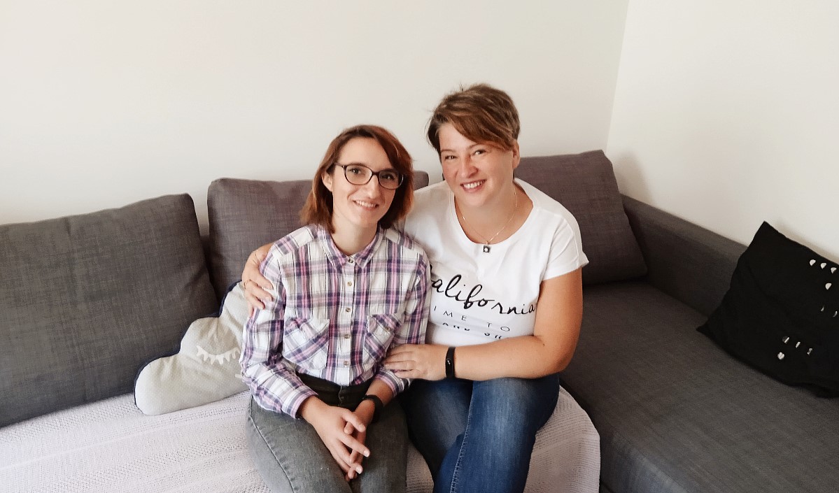 Dwie uśmiechnięte kobiety siedzą na sofie