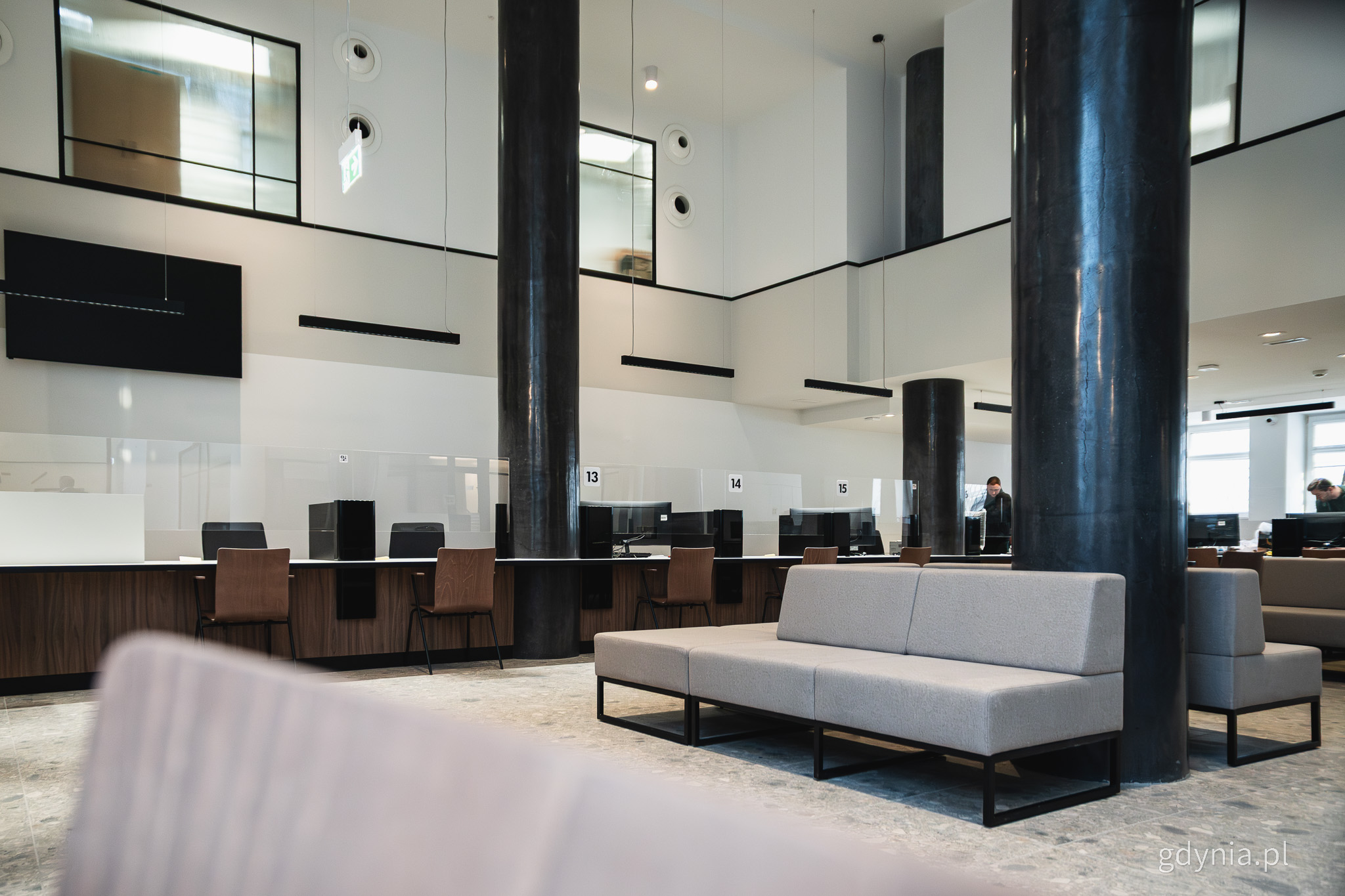 Sala obsługi, widoczne stanowiska, sofy dla oczekujących, numery stanowisk
