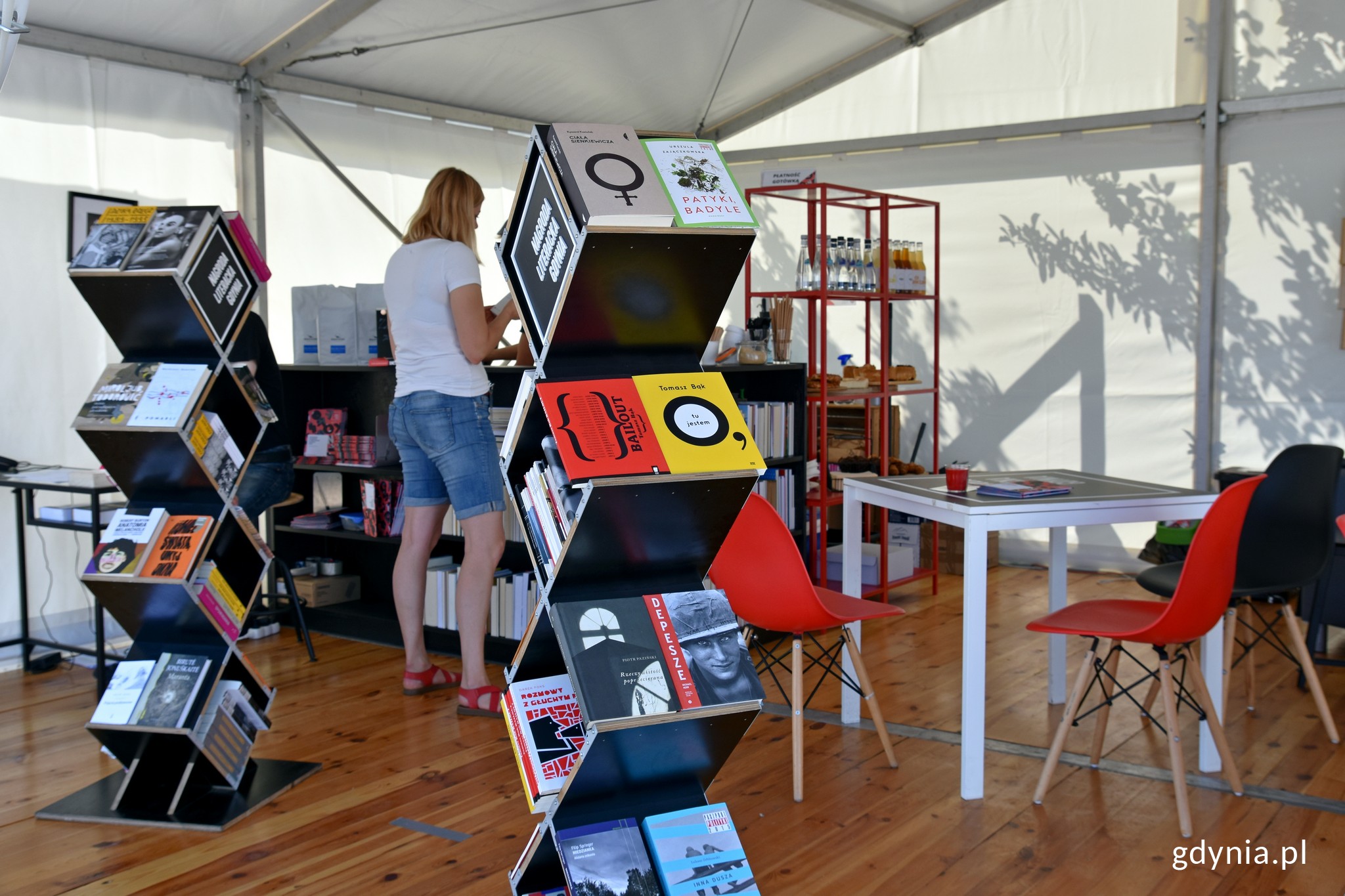 Kawiarnia Nagrody Literackiej Gdynia i dwa stojaki z książkami laureat&oacute;w i nominowanych do NLG // fot. Magdalena Czernek
