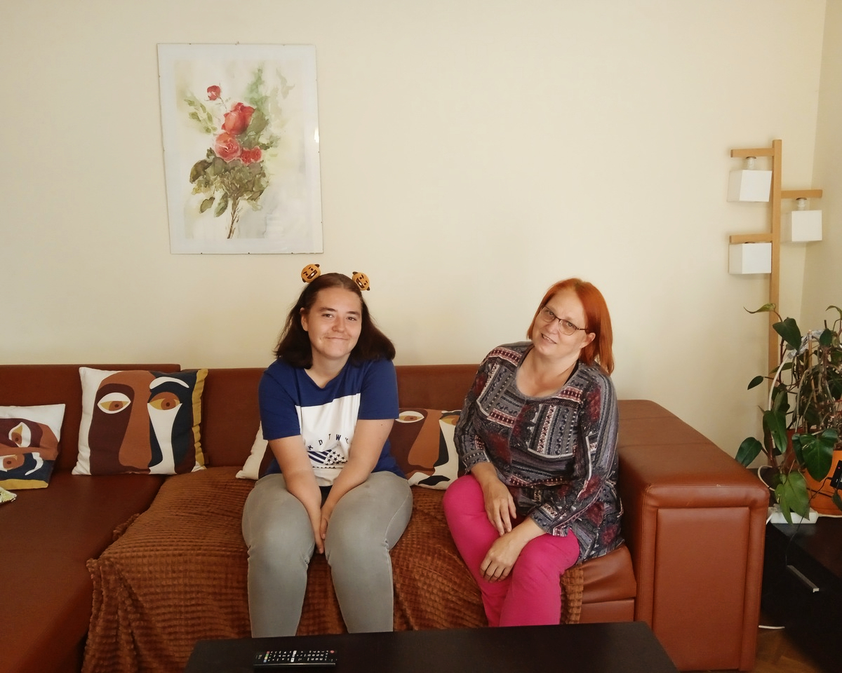 dwie kobiety siedzą na szerokiej kanapie 