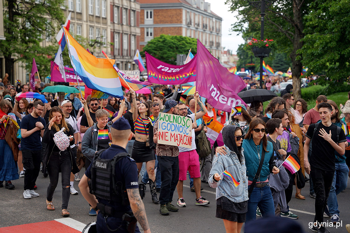 Ulica w Gdańsku, tłum ludzi w kolorowych ubraniach, tęczowe flagi, transparenty w tłumie