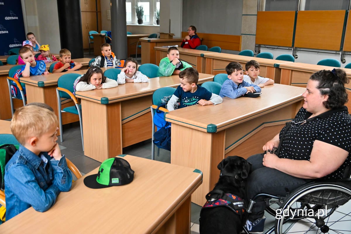 marta Czachor z UM Gdynia z psem asystującym Delicją, opowiada dzieciom o swojej pracy w urzędzie.