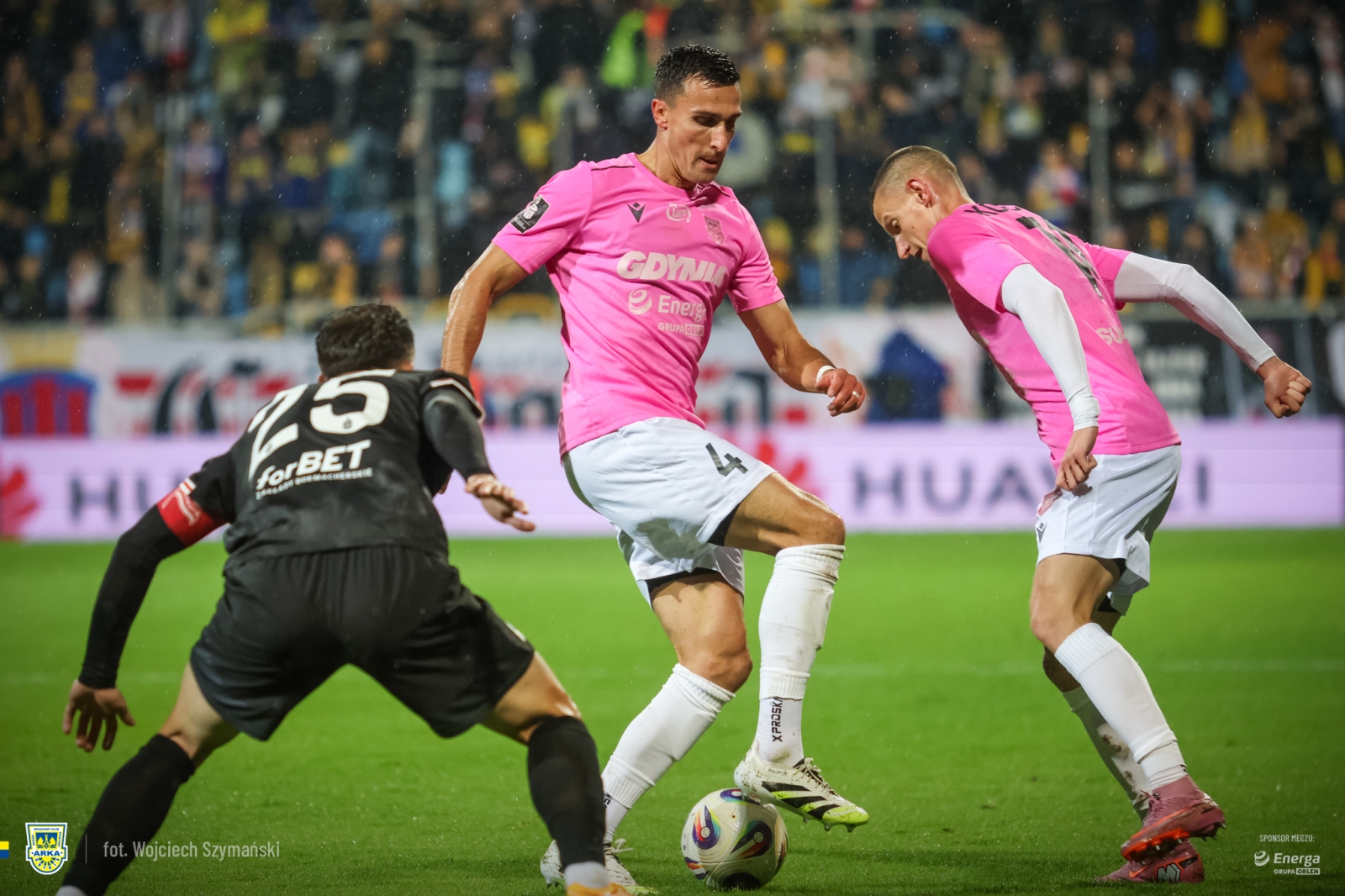 Stadion w Gdyni, dwaj piłkarze Arki w r&oacute;żowych koszulkach