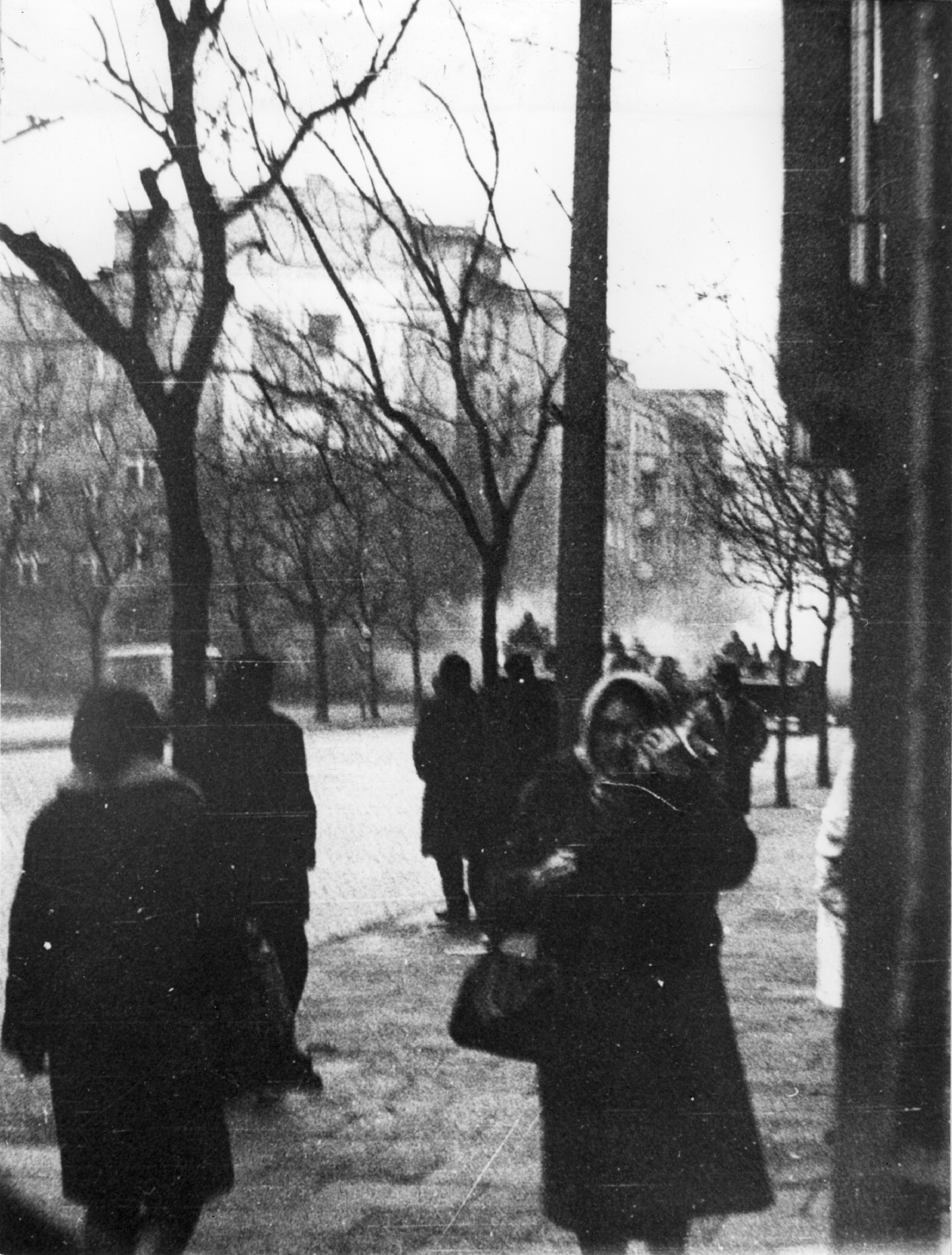 Ulica Świętojańska w Gdyni na wysokości kościoła NMP Kr&oacute;lowej Polski. W głębi widać czołgi jadące od strony Urzędu Miasta. Na pierwszym planie ludzie idący chodnikiem // źr&oacute;dło: IPN