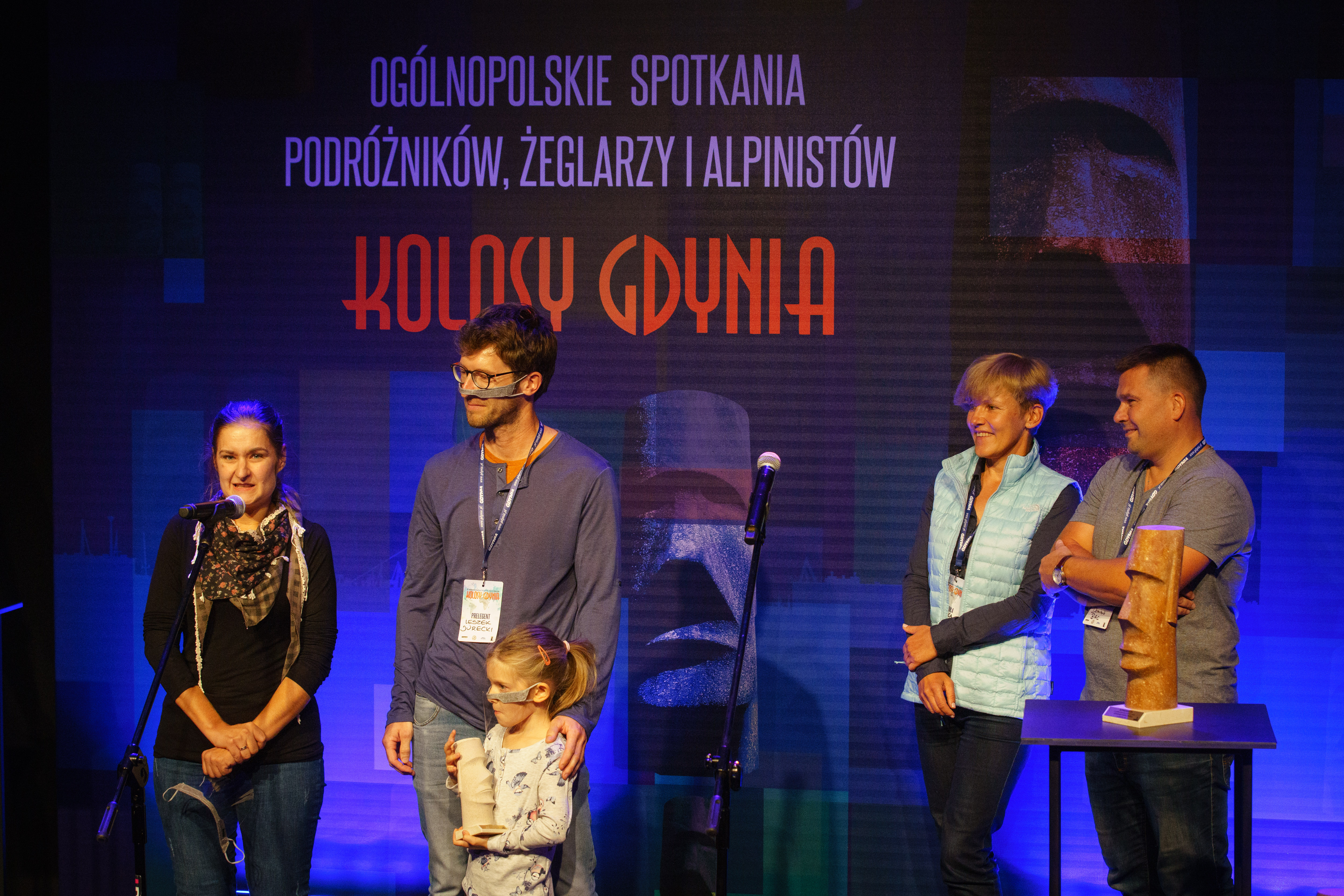 Dagmara, Dobrawa i Leszek Jureccy na scenie ze statuetką. Z nimi członkowie kapituły Kolos&oacute;w // fot. Anna Rezulak
