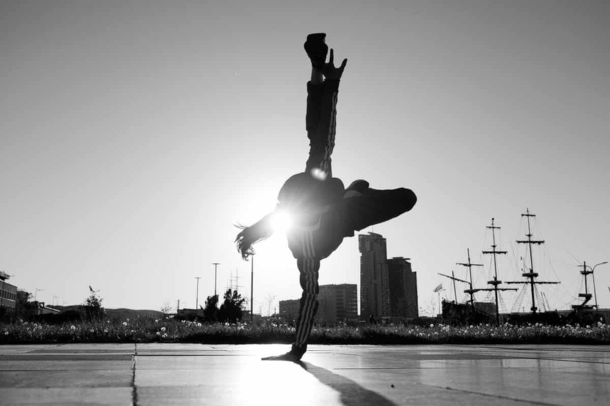 Dziewczyna tańcząca breaking na boisku asfaltowym