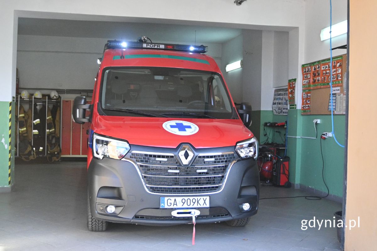 Czerwony furgon w garażu ze sprzętem strażackim