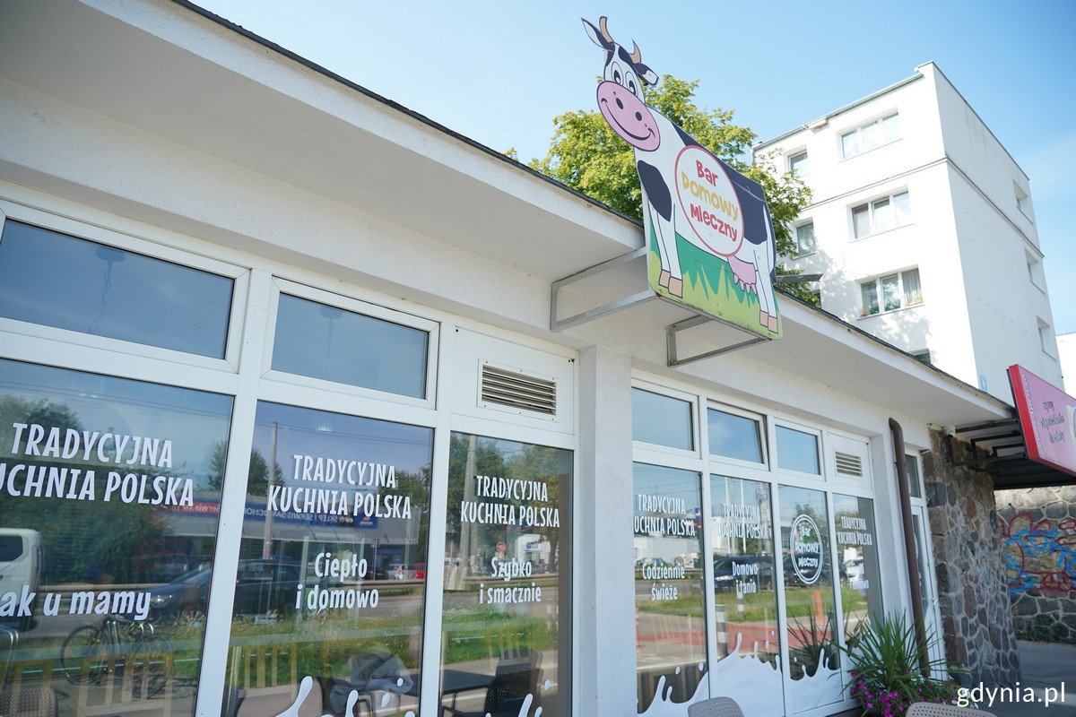 Bar domowy z zewnątrz: wejście i szyld z krową