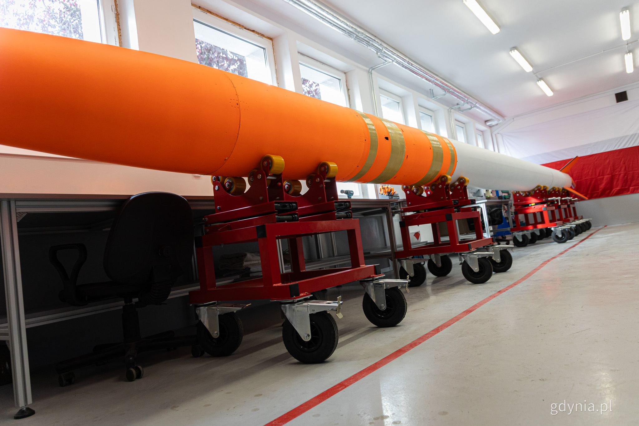 Hala produkcyjna, na stelażach szaro-pomarańczowa rakieta Perun