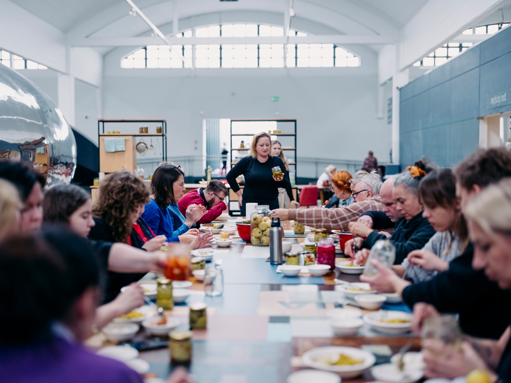 St&oacute;ł z potrawami i siedzącymi przy nim ludźmi podczas urodzin Dworca Morskiego