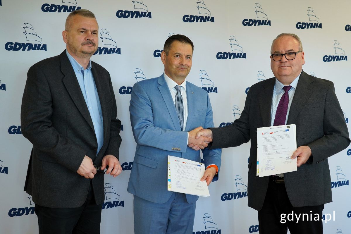 Tomasz Labuda - zastępca prezesa zarządu PKT, Piotr Małolepszy - prezes zarządu PKT i Andrzej Sienkiewicz - dyrektor sprzedaży krajowej Solaris Bus & Coach Sp. z o.o. trzymający egzemplarze podpisanej umowy