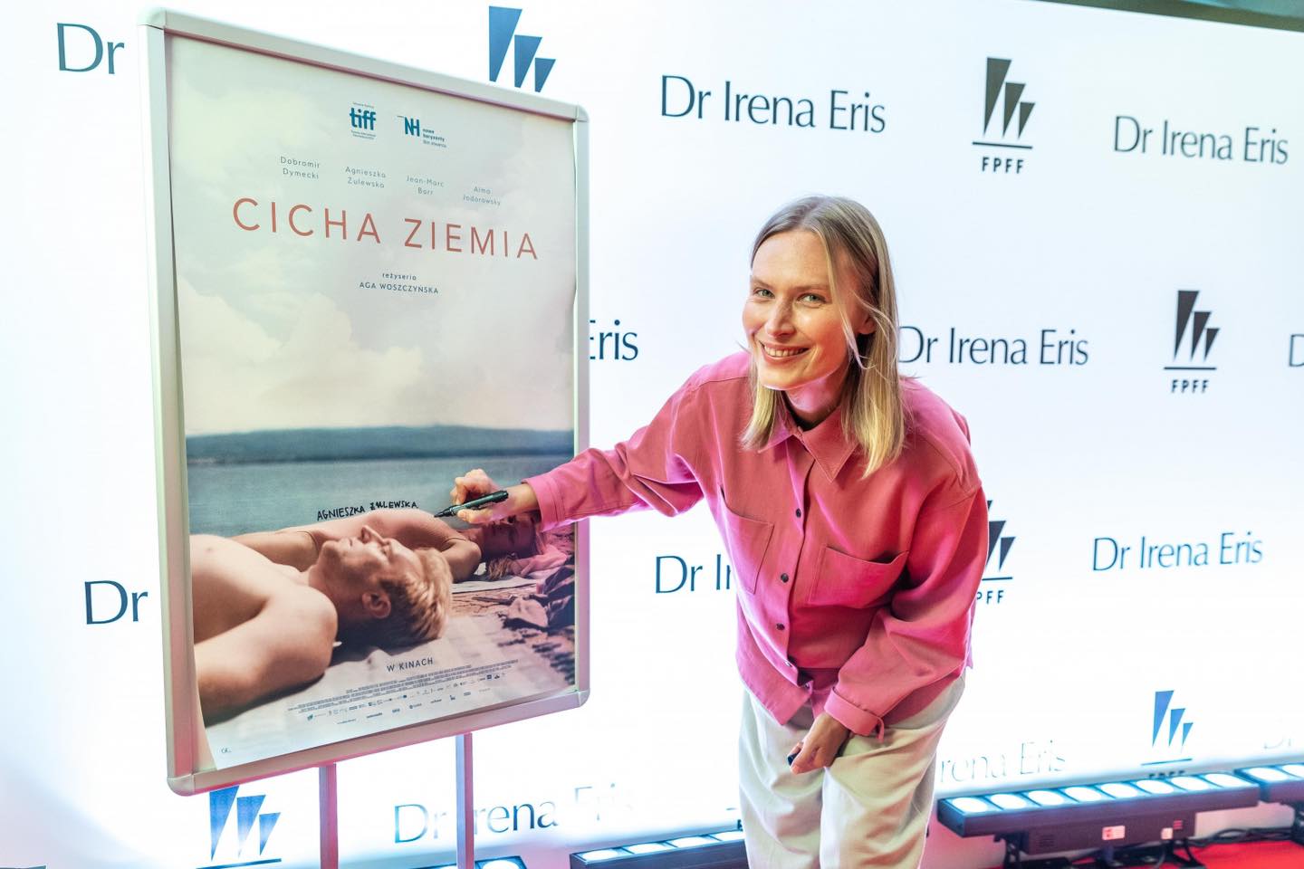 Agnieszka Żulewska przy plakacie filmu &bdquo;Cicha ziemia&rdquo; , fot. Anna Bobrowska / FPFF