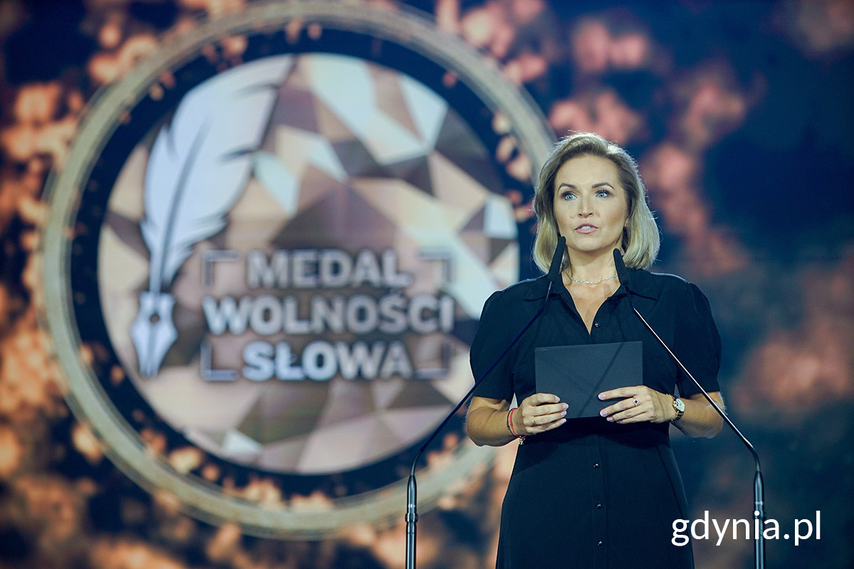 Werornika Mirowska, przemawia do mikrofonu, w tle dekoracja sceny