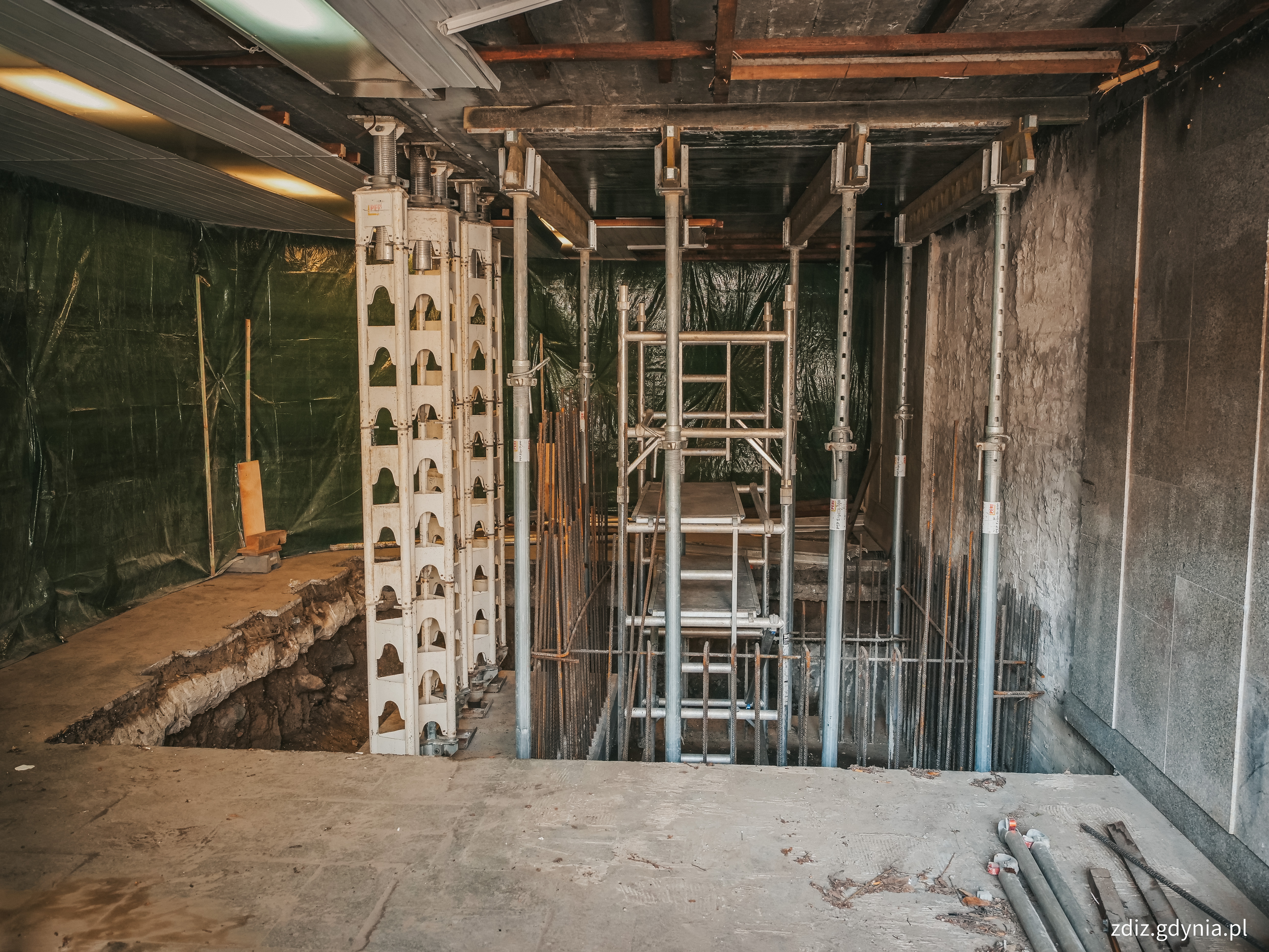 widoczna konstrukcja szybu windowego na ogrodzonym terenie budowy