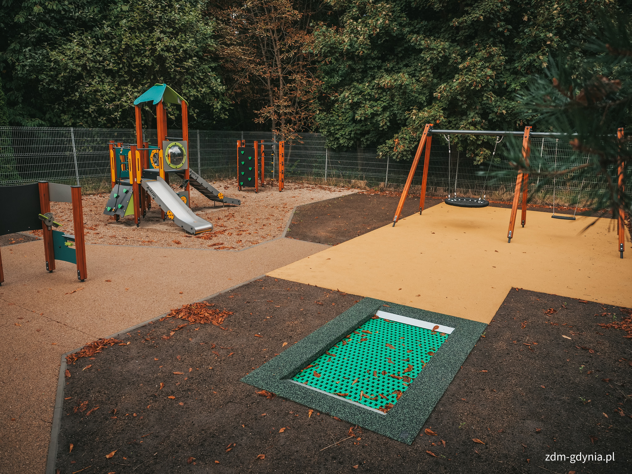 Huśtawki, zestaw zabawowy ze zjeżdżalnią i trampolina na placu zabaw przy SP nr 44 (fot. Marcin Mielewski, Zarząd Dr&oacute;g Miejskich)