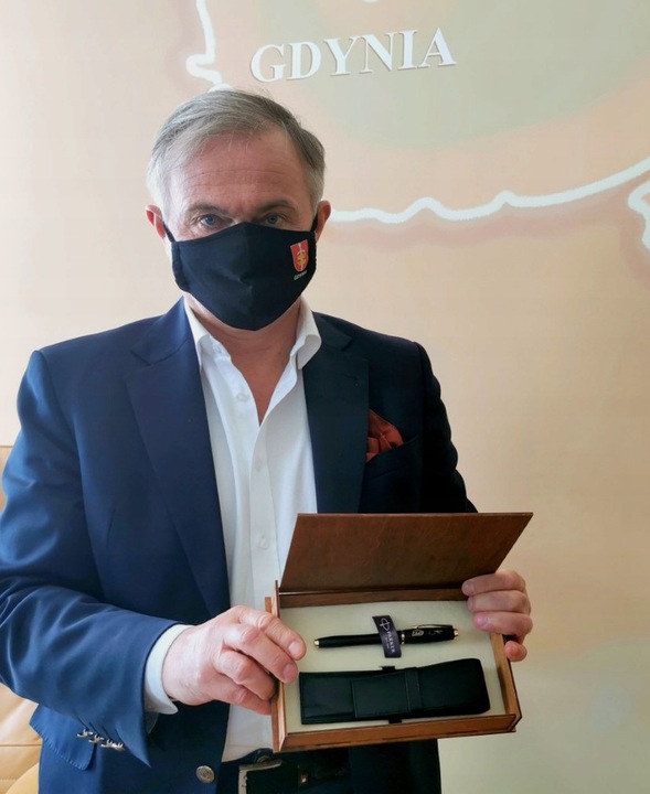 Prezydent Gdyni Wojciech Szczurek z drewnianą szkatułką, w kt&oacute;rej znajdują się: pi&oacute;ro marki Parker z podpisem prezydenta oraz sk&oacute;rzany pokrowiec na pi&oacute;ro // materiały prasowe