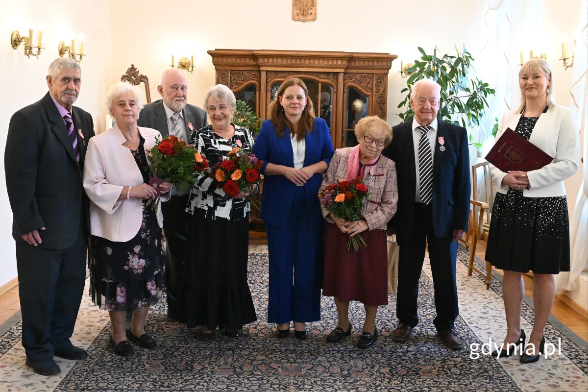 Seniorzy stojący w eleganckiej sali