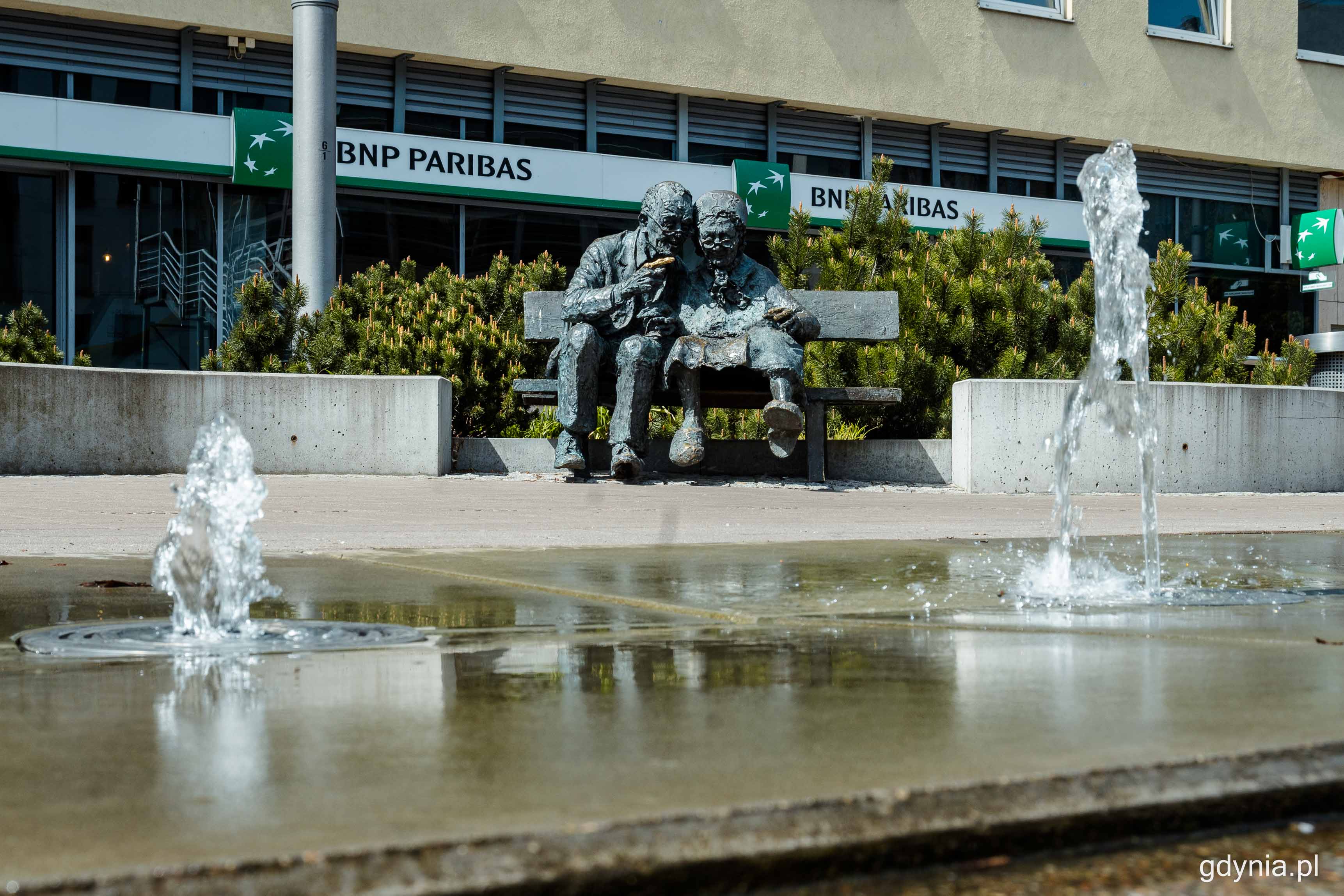 Fontannie na pl. Kaszubskim przygląda się para Kaszub&oacute;w z ławeczki - pomnika. Fot. Kamil Złoch