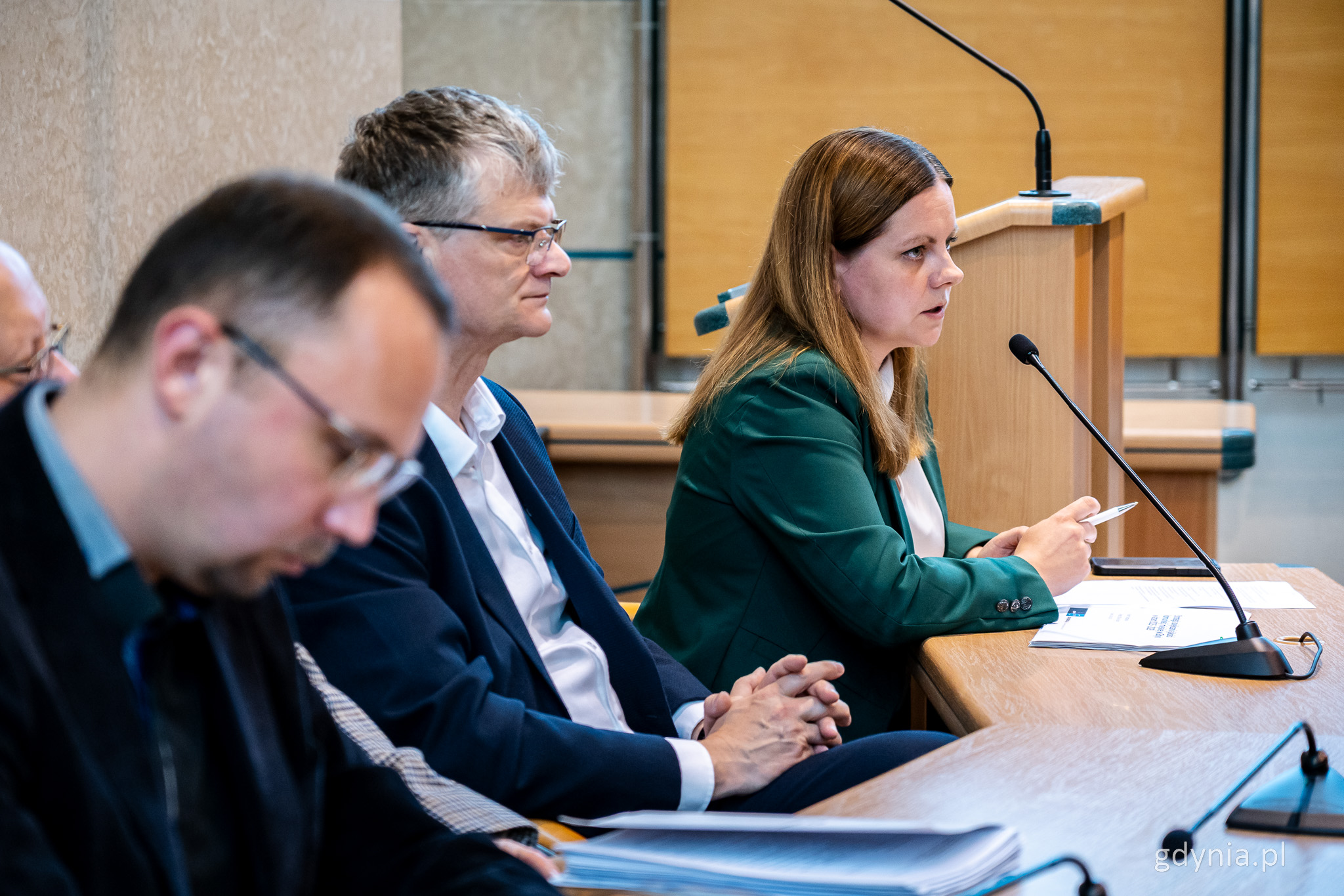 Sala obrad rady miasta, gdy stole Rafał Geremek i Aleksandra Kosiorek - prezydent przemawia przez mikrofon
