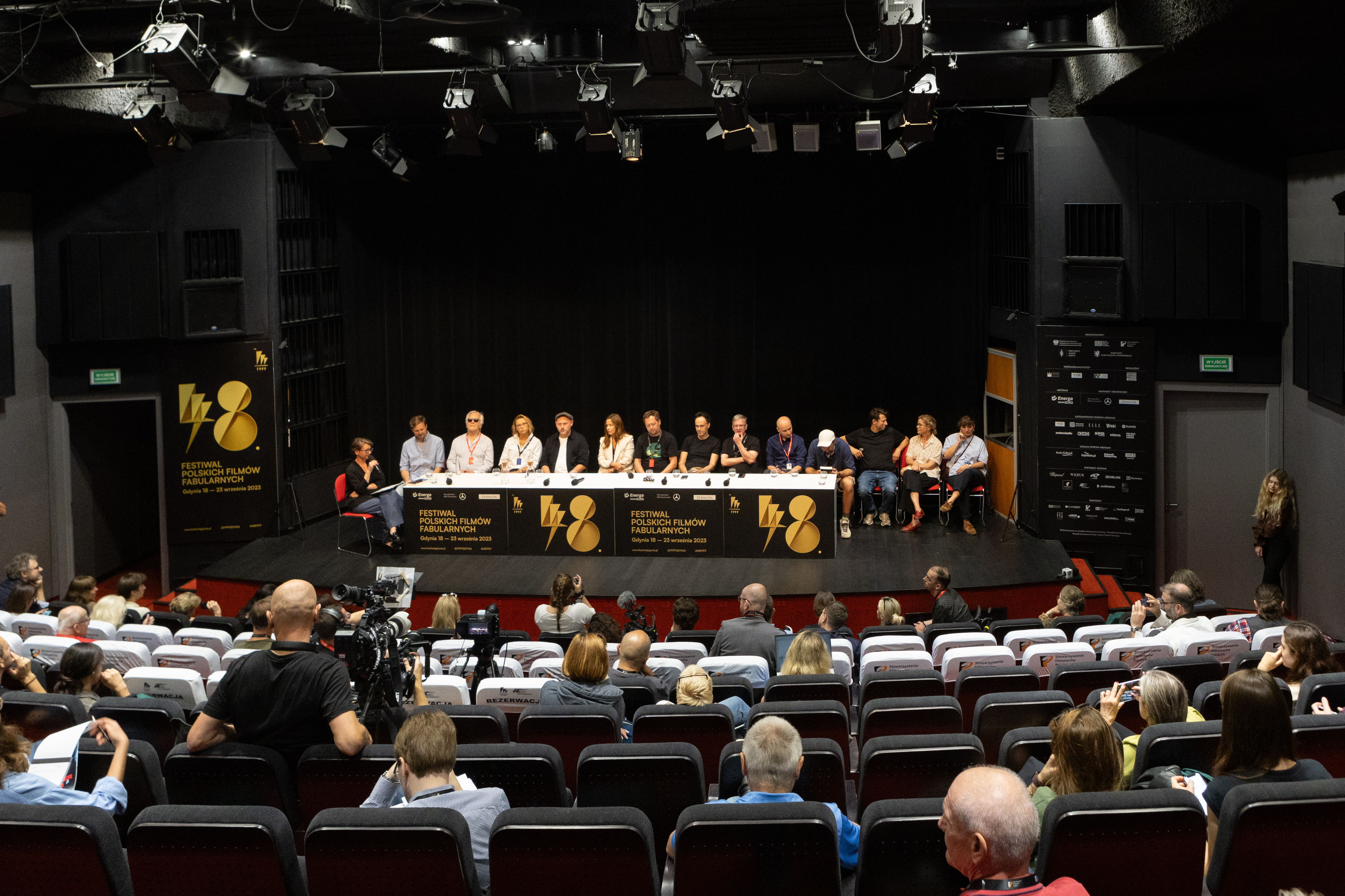 Sala Warszawa w GCF, ludzie na widowni, na scenie st&oacute;ł i kilkanaście os&oacute;b bierze udział w konferencji prasowej