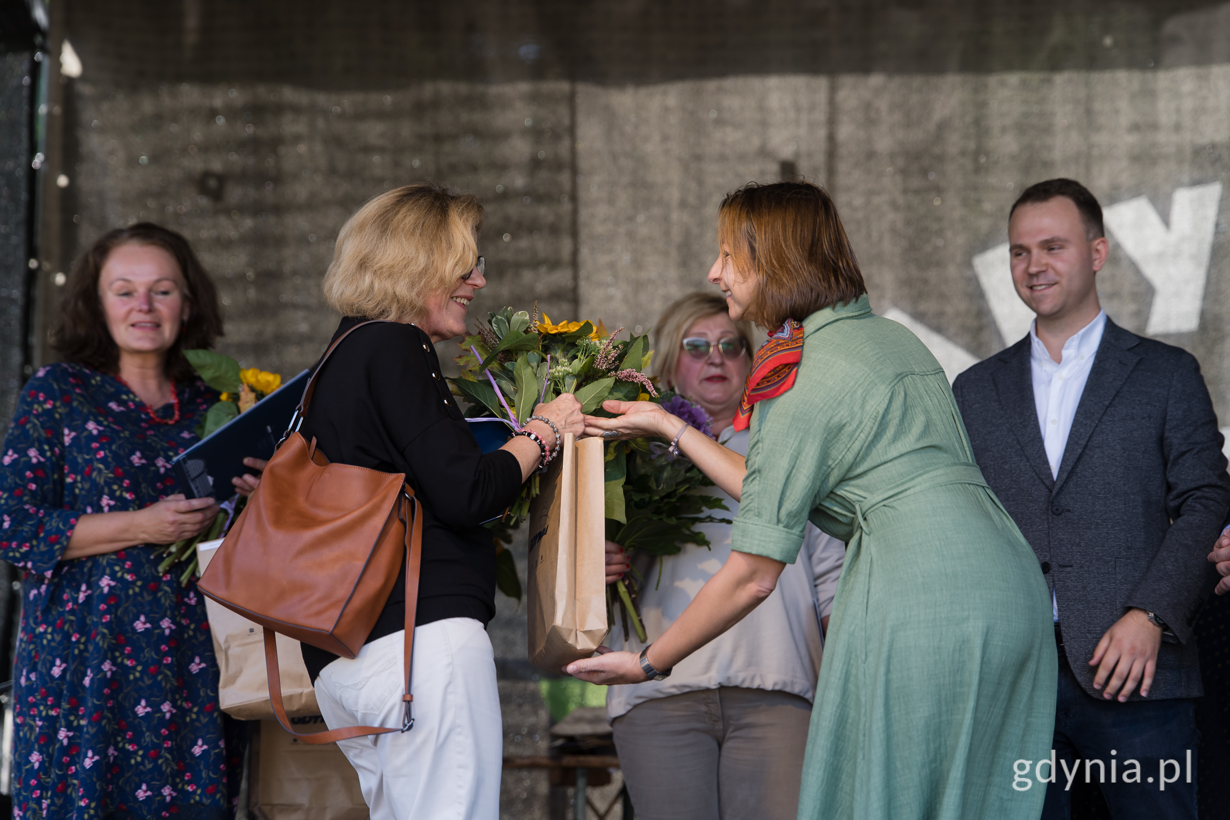 Ludzie na scenie z kwiatami